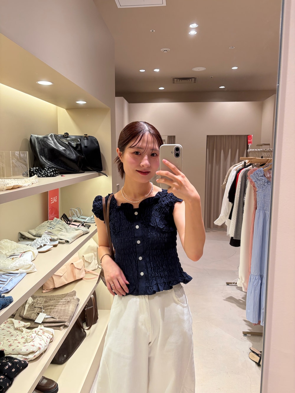 ブルー系のシャツ/ブラウス、ホワイト系のデニムパンツを着用したレディースの夏コーディネートの2枚目の写真