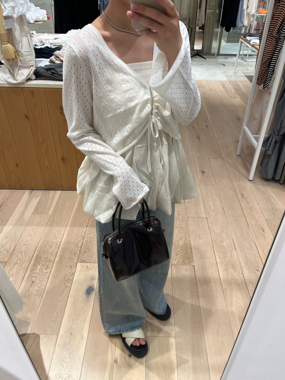 ホワイト系のシャツ/ブラウス、ホワイト系のカーディガン/ボレロ、ブルー系のデニムパンツを着用したレディースの夏コーディネートの3枚目の写真