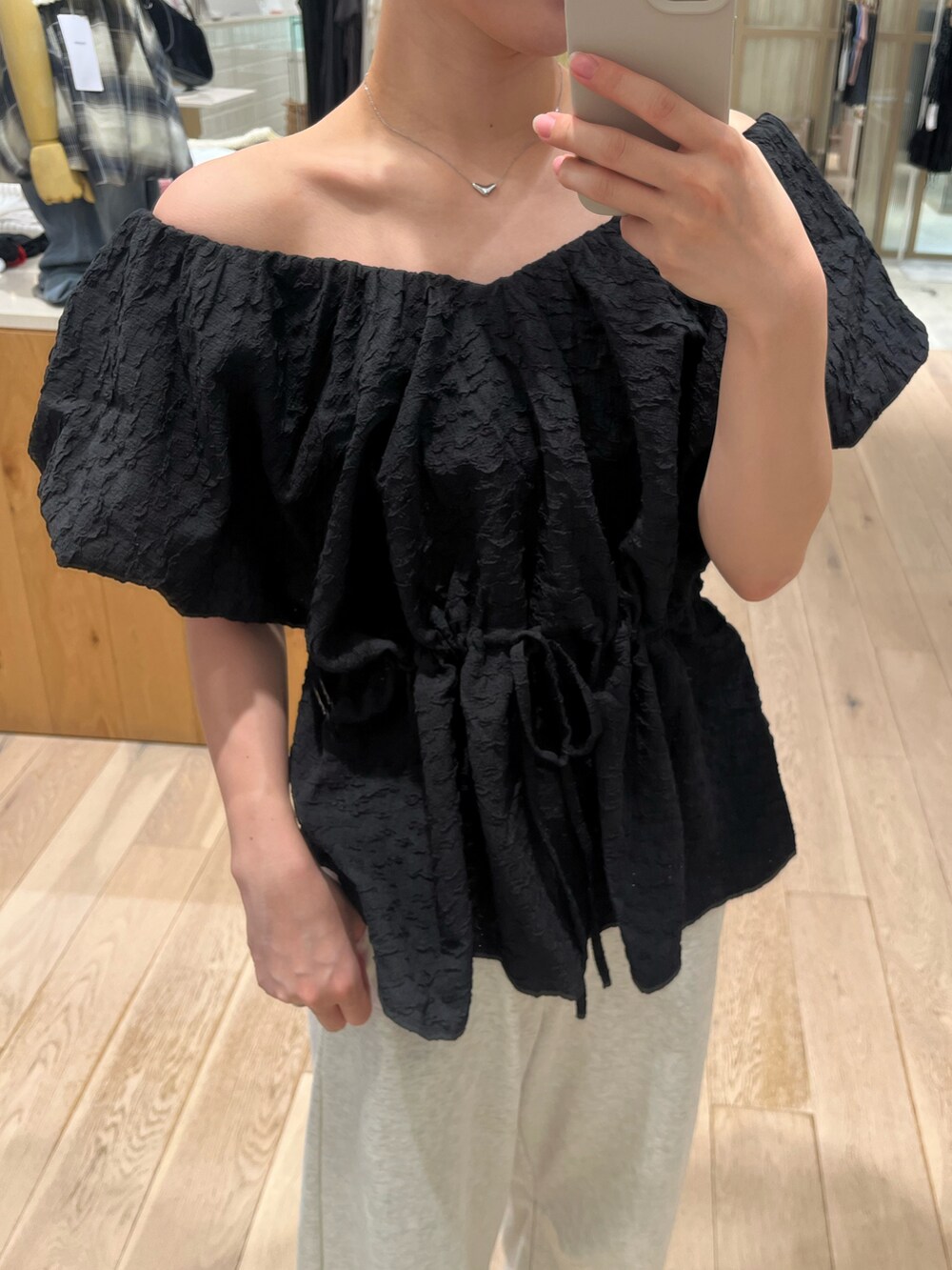 ブラック系のシャツ/ブラウス、ホワイト系のスウェットパンツを着用したレディースの夏コーディネートの2枚目の写真