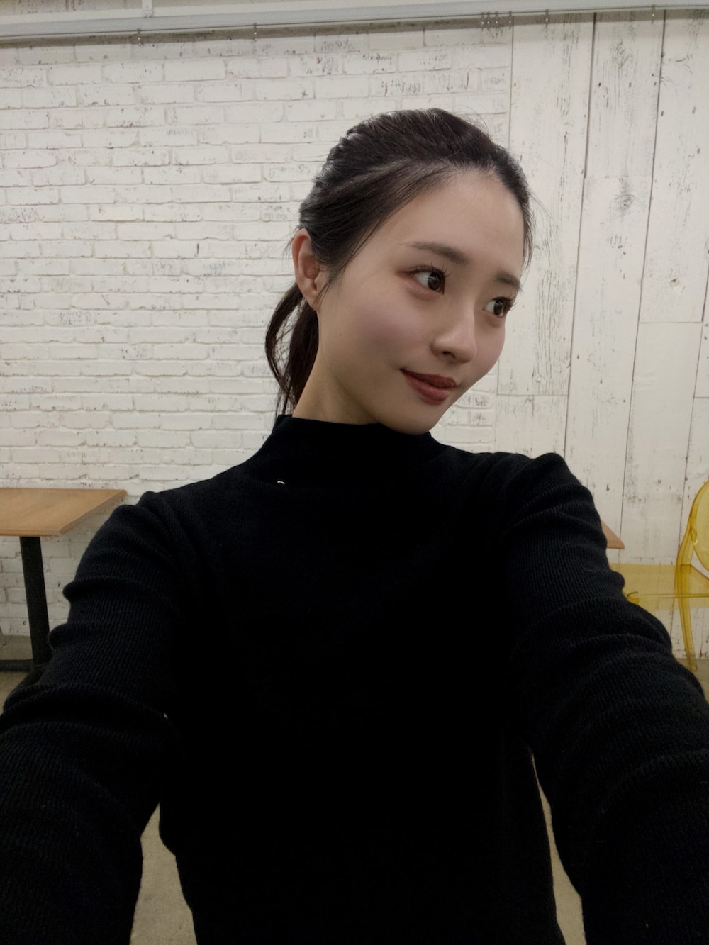 ホワイト系のスカート、ブラック系のニット/セーター、ブラック系のブーツを着用したレディースの秋コーディネートの2枚目の写真