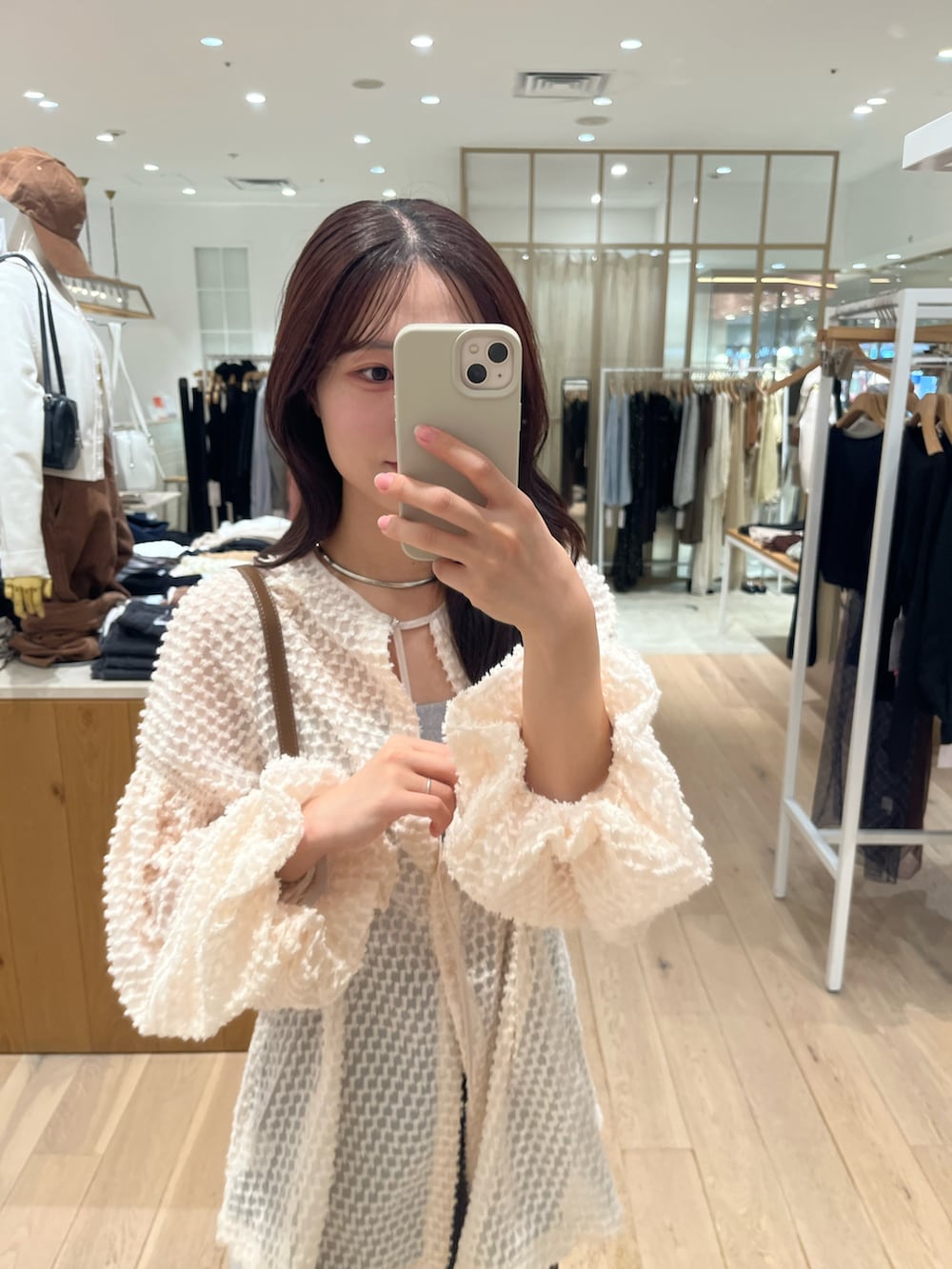 ブラック系のデニムパンツ、ピンク系のチュニック、グレー系のキャミソールを着用したレディースの秋コーディネートの3枚目の写真