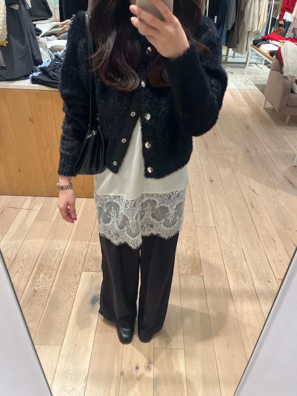 ブラック系のブーツ、ブラック系のカーディガン/ボレロ、ホワイト系のキャミソールを着用したレディースの秋コーディネートの3枚目の写真