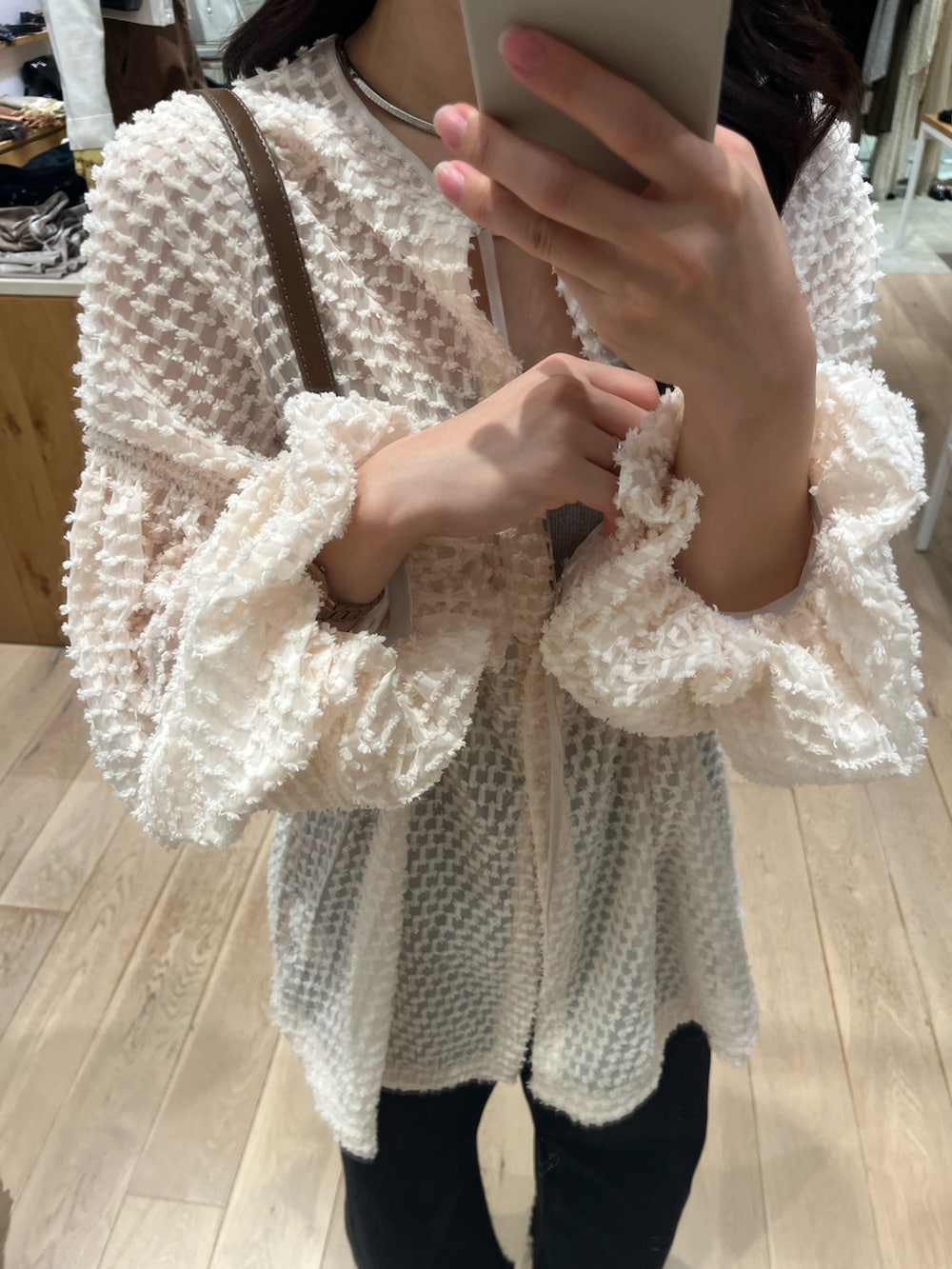 ブラック系のデニムパンツ、ピンク系のチュニック、グレー系のキャミソールを着用したレディースの秋コーディネートの2枚目の写真