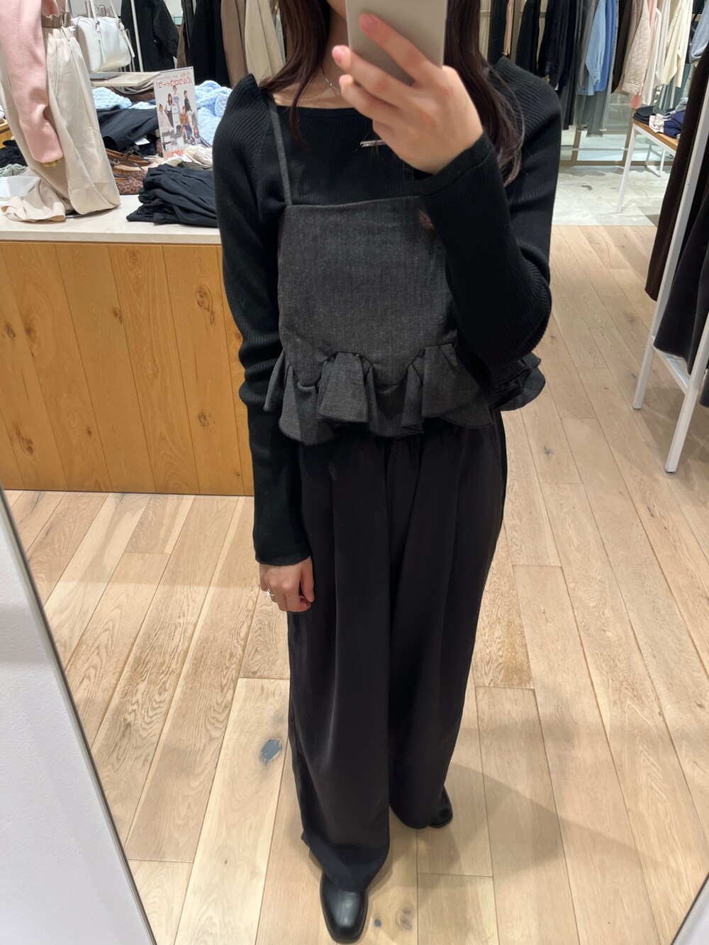 ブラック系のスラックス、グレー系のシャツ/ブラウス、ブラック系のニット/セーターを着用したレディースの秋コーディネートの2枚目の写真