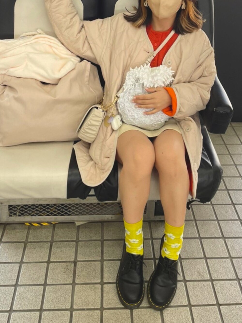 オレンジ系のノーカラージャケット、ブラック系のドレスシューズ、オレンジ系のニット/セーターを着用したレディースの春コーディネートの2枚目の写真