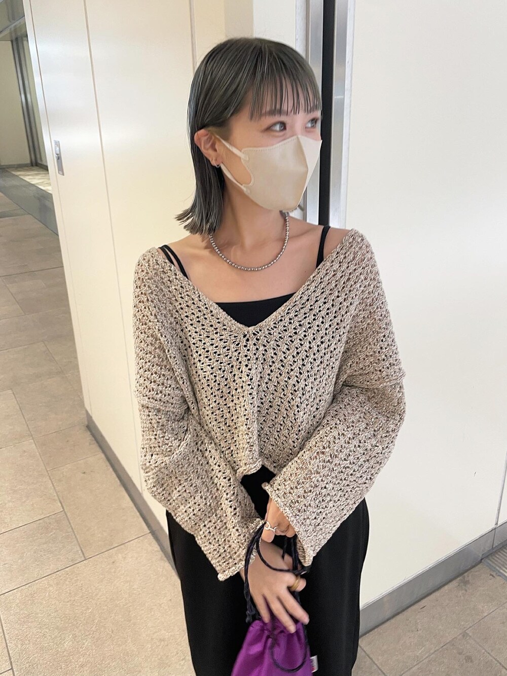 ベージュ系のニット/セーター、ブラック系のつなぎ/オールインワンを着用したレディースの夏コーディネートの2枚目の写真