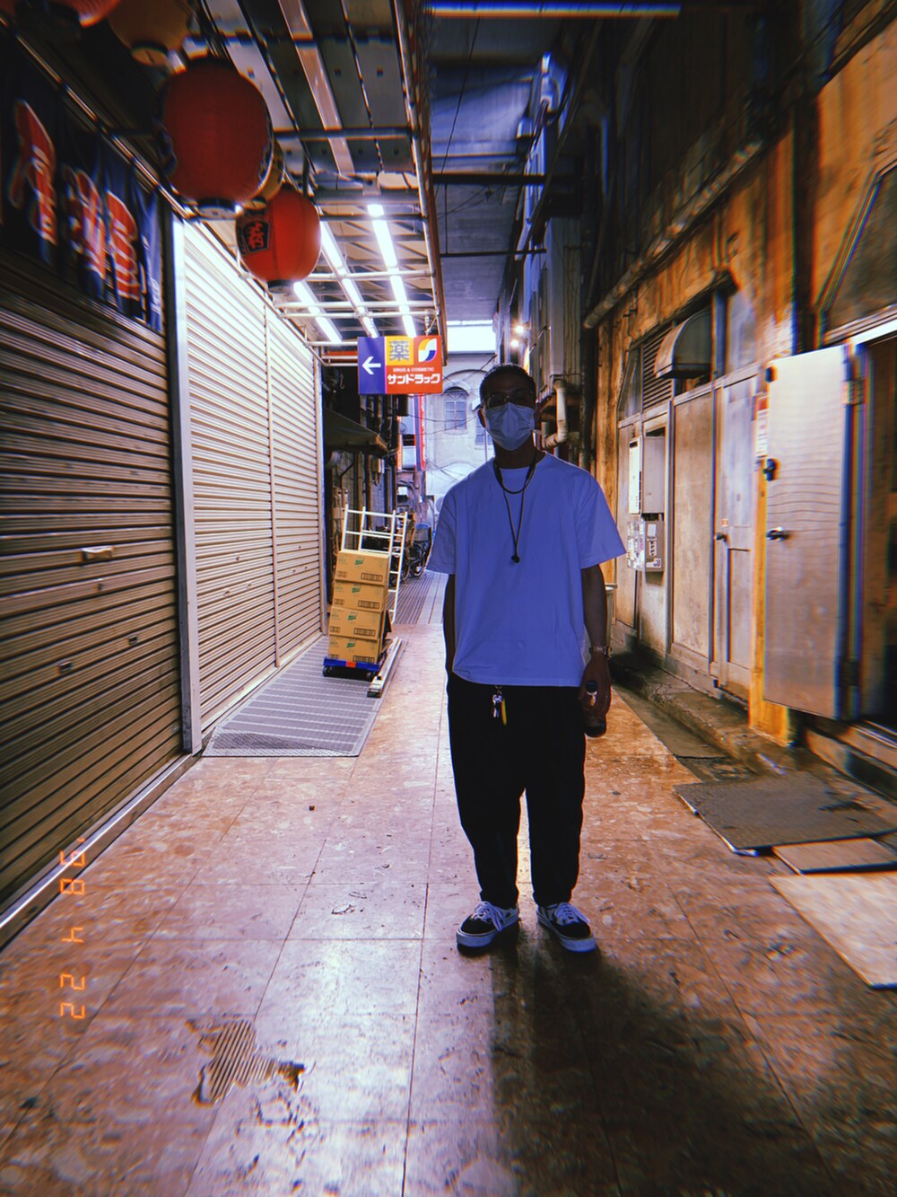 ホワイト系のTシャツ/カットソー、ブラック系のチノパンツ、ブラック系のスニーカーを着用したメンズの春コーディネートの2枚目の写真