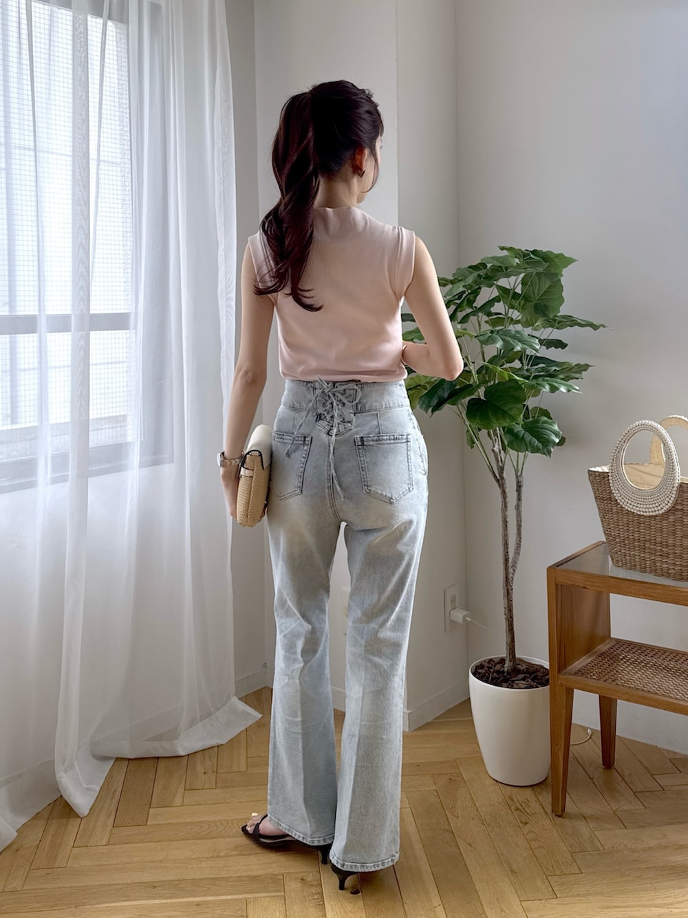 ピンク系のキャミソール、ブルー系のデニムパンツ、ブラック系のサンダルを着用したレディースの春コーディネートの3枚目の写真
