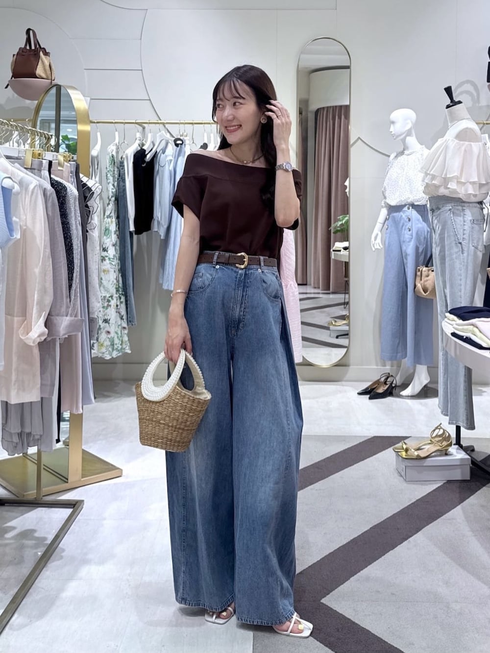 ブラウン系のニット/セーター、ブルー系のその他パンツ、ベージュ系のかごバッグを着用したレディースの夏コーディネートの2枚目の写真