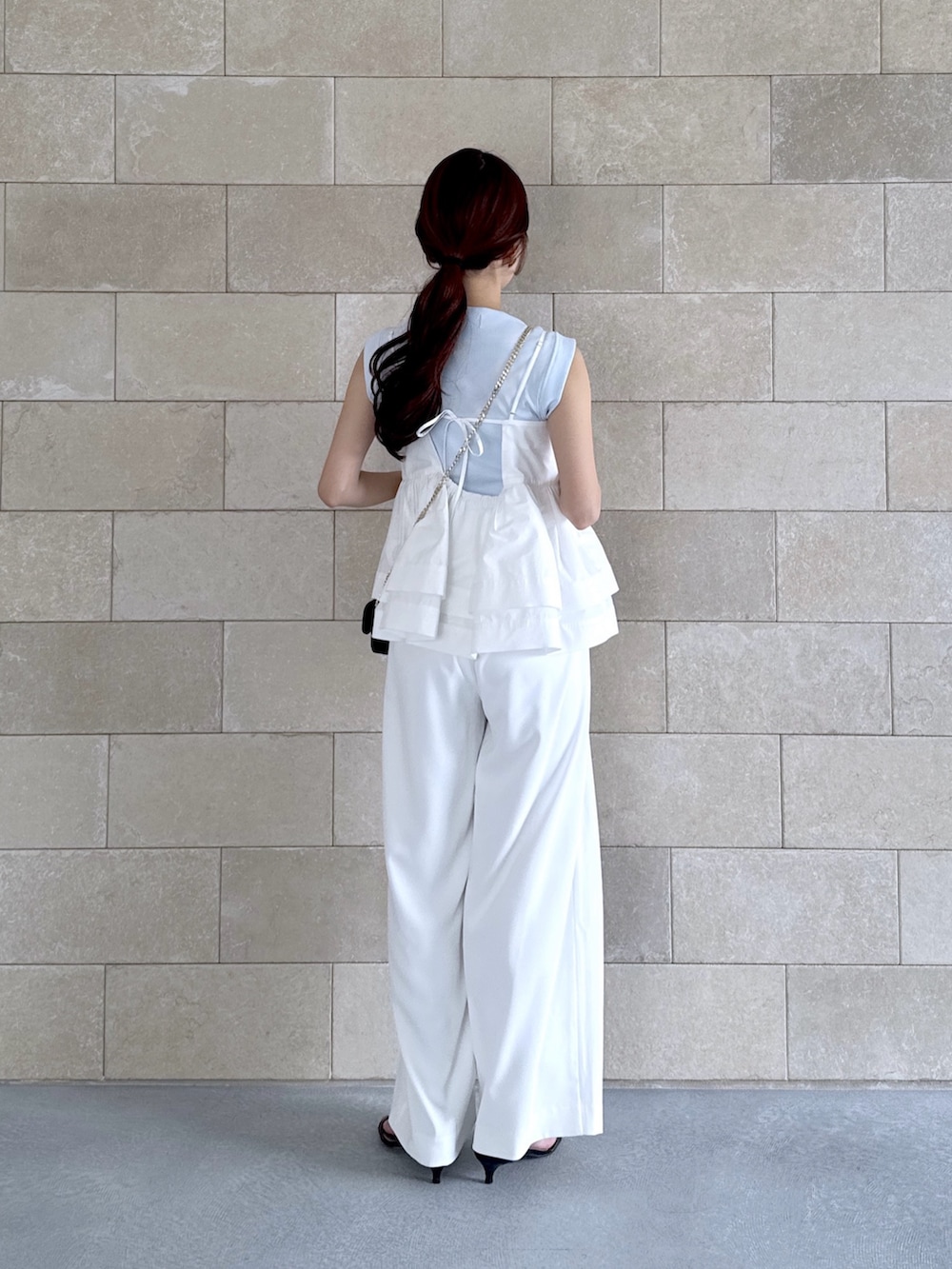 ホワイト系のスラックス、ホワイト系のシャツ/ブラウス、ブルー系のタンクトップを着用したレディースの夏コーディネートの4枚目の写真