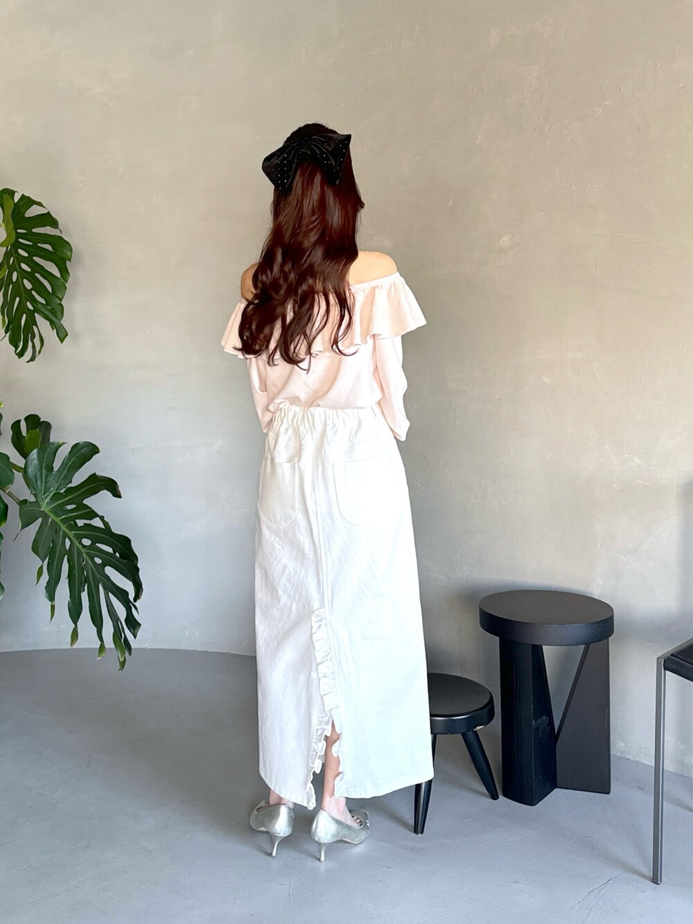 ピンク系のニット/セーター、ベージュ系のかごバッグ、ホワイト系のスカートを着用したレディースの春コーディネートの3枚目の写真