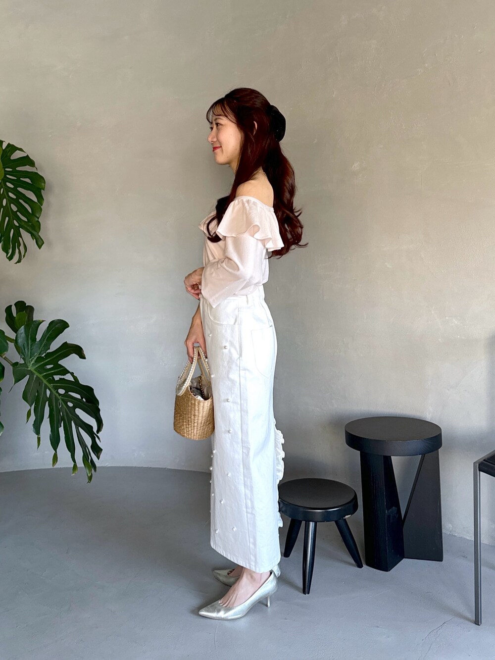 ピンク系のニット/セーター、ベージュ系のかごバッグ、ホワイト系のスカートを着用したレディースの春コーディネートの2枚目の写真