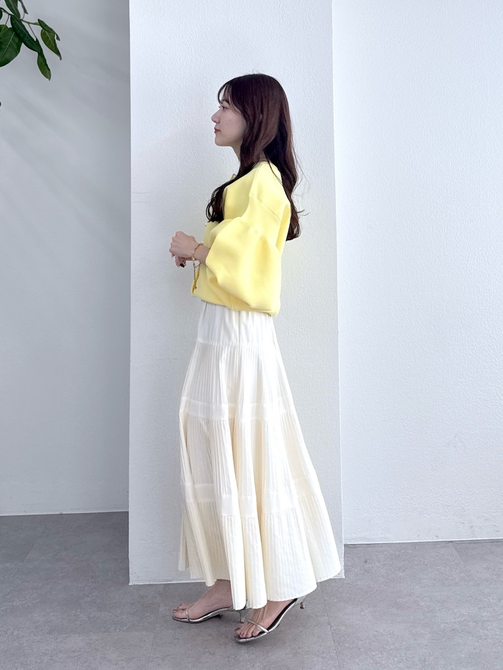 イエロー系のカーディガン/ボレロ、ホワイト系のスカートを着用したレディースの冬コーディネートの3枚目の写真