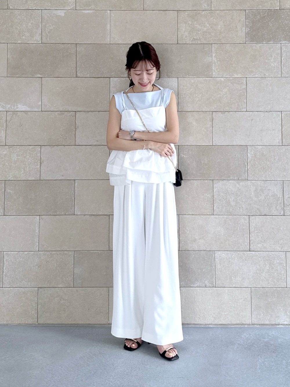 ホワイト系のスラックス、ホワイト系のシャツ/ブラウス、ブルー系のタンクトップを着用したレディースの夏コーディネートの2枚目の写真
