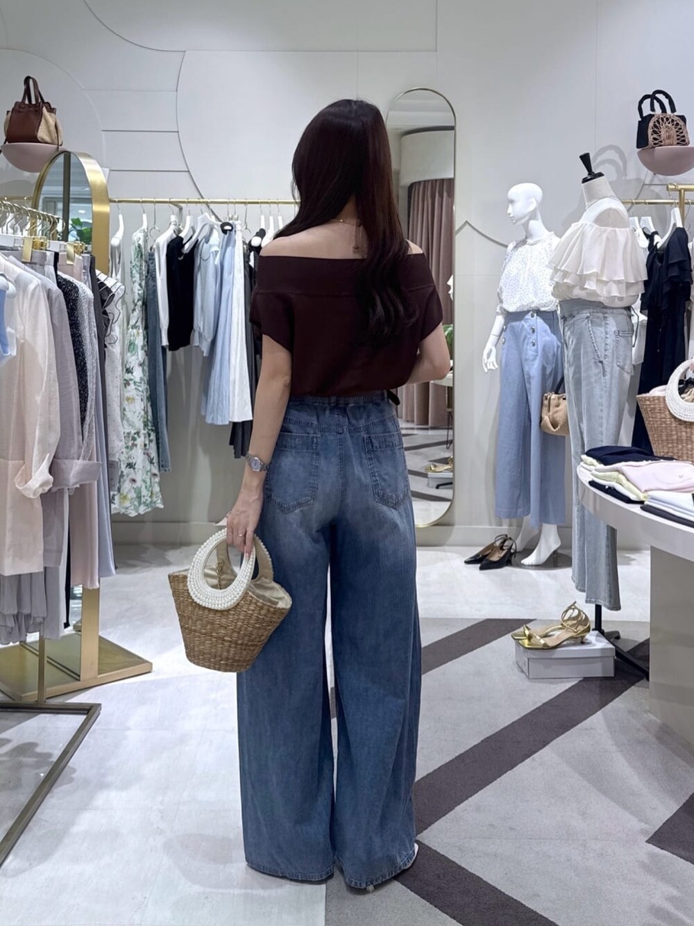 ブラウン系のニット/セーター、ブルー系のその他パンツ、ベージュ系のかごバッグを着用したレディースの夏コーディネートの4枚目の写真