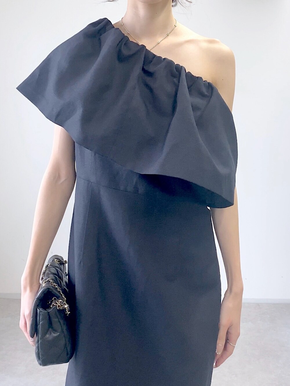 ブルー系のワンピース、ブラック系のショルダーバッグを着用したレディースの春コーディネートの4枚目の写真