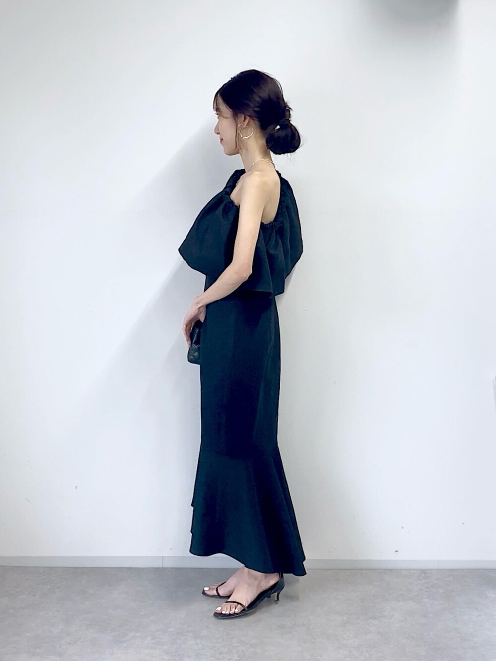 ブルー系のワンピース、ブラック系のショルダーバッグを着用したレディースの春コーディネートの2枚目の写真