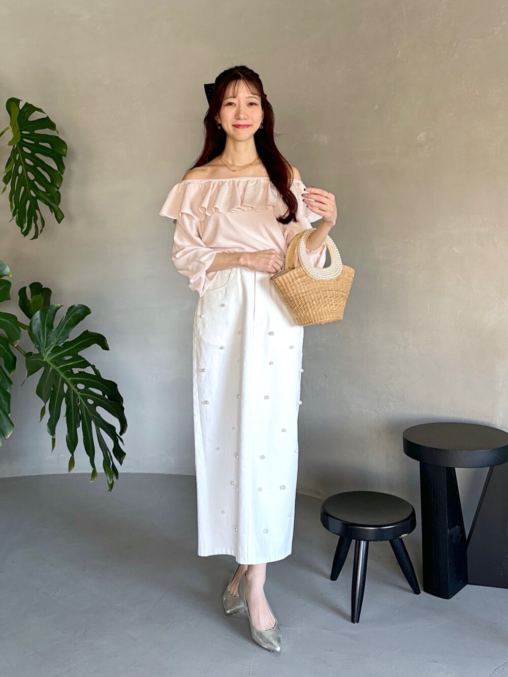 ピンク系のニット/セーター、ベージュ系のかごバッグ、ホワイト系のスカートを着用したレディースの春コーディネートの5枚目の写真