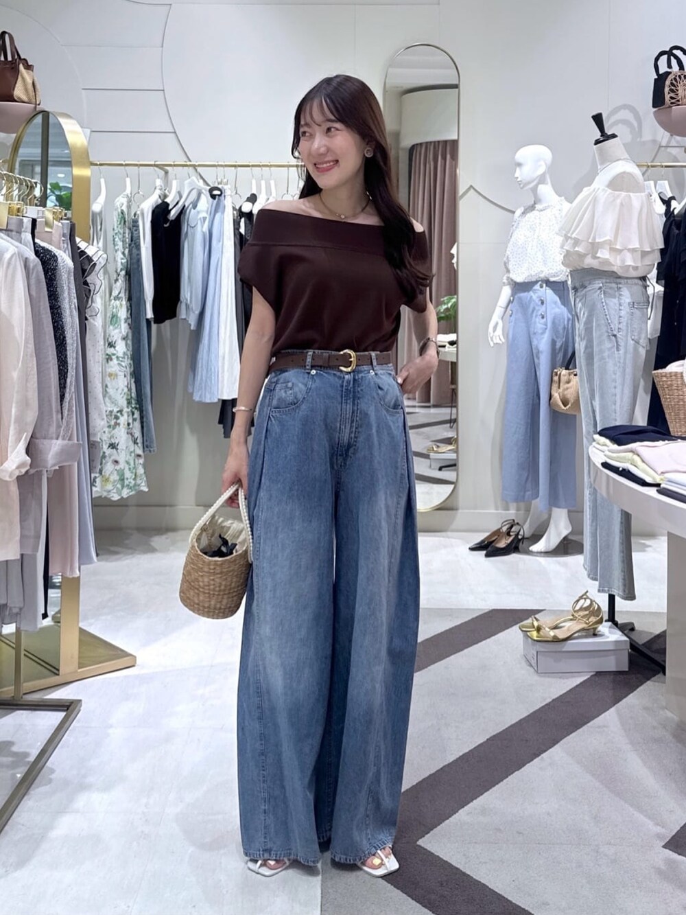 ブラウン系のニット/セーター、ブルー系のその他パンツ、ベージュ系のかごバッグを着用したレディースの夏コーディネートの5枚目の写真