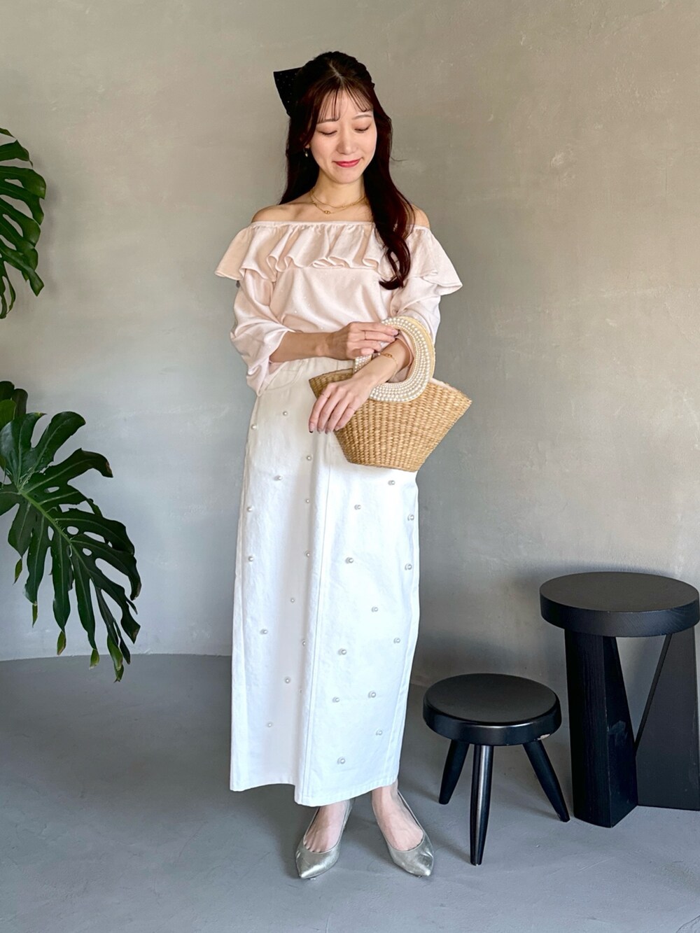 ピンク系のニット/セーター、ベージュ系のかごバッグ、ホワイト系のスカートを着用したレディースの春コーディネートの4枚目の写真