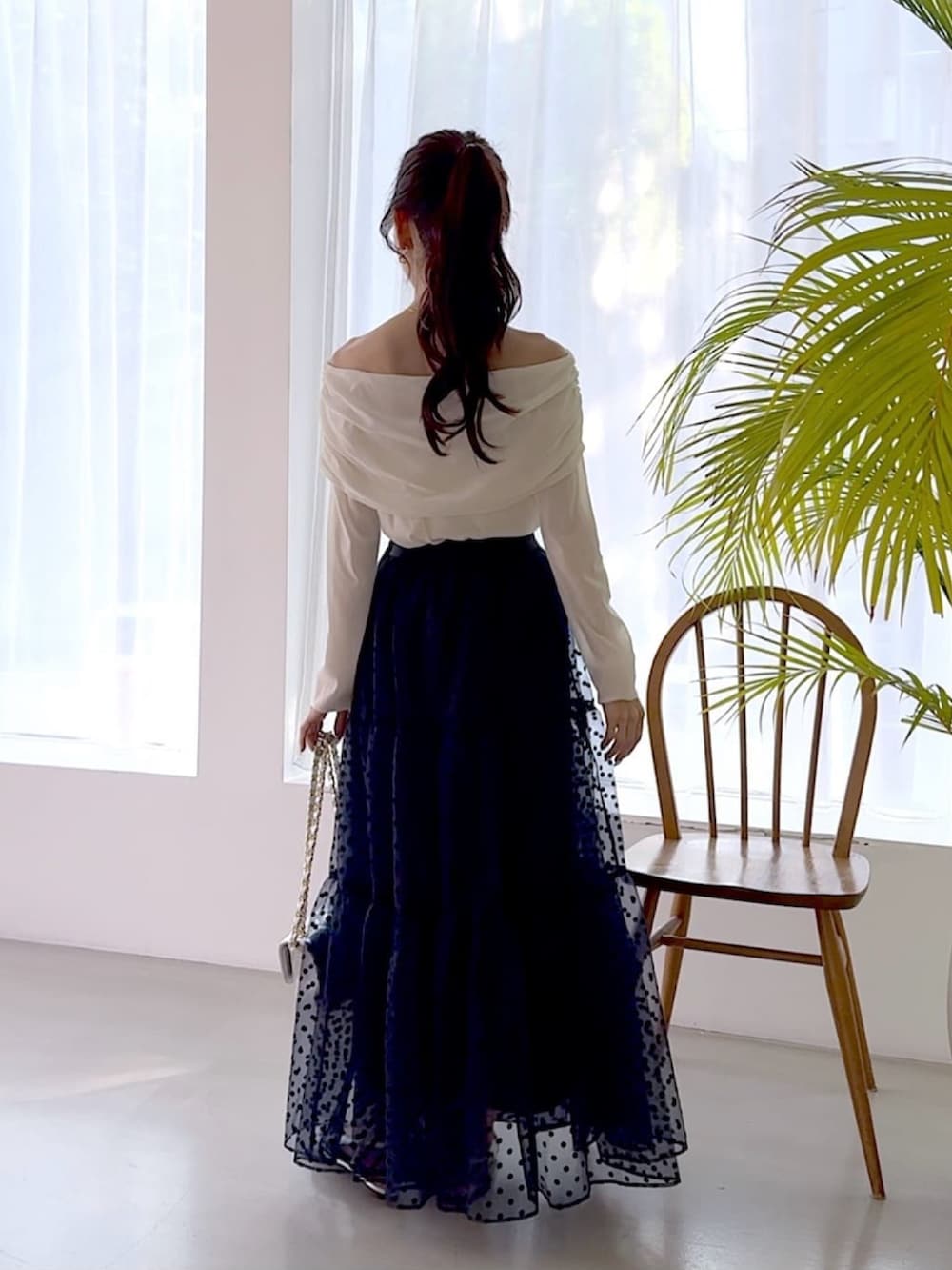 ホワイト系のTシャツ/カットソー、ブルー系のスカート、シルバー系のショルダーバッグを着用したレディースの秋コーディネートの3枚目の写真