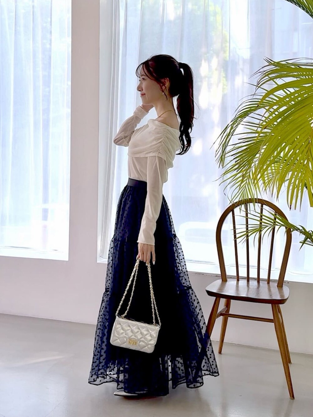 ホワイト系のTシャツ/カットソー、ブルー系のスカート、シルバー系のショルダーバッグを着用したレディースの秋コーディネートの2枚目の写真