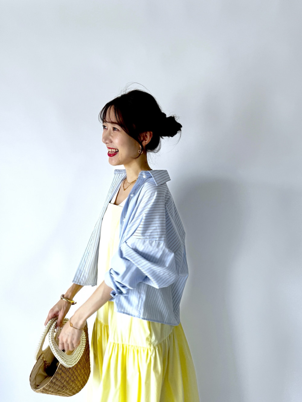 イエロー系のワンピース、ブルー系のシャツ/ブラウス、ホワイト系のタンクトップを着用したレディースの夏コーディネートの5枚目の写真