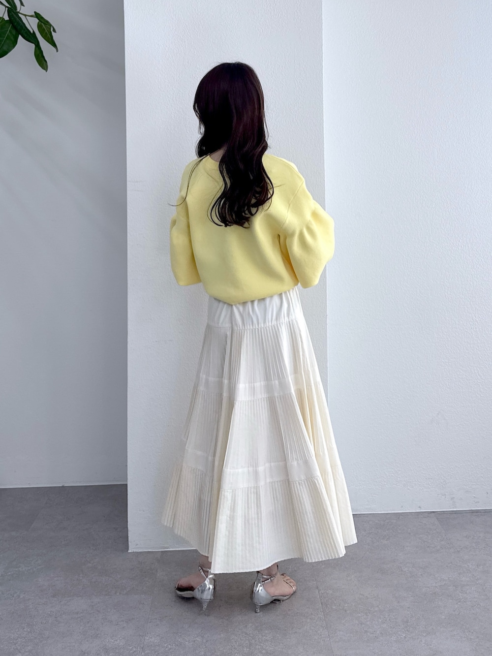 イエロー系のカーディガン/ボレロ、ホワイト系のスカートを着用したレディースの冬コーディネートの4枚目の写真