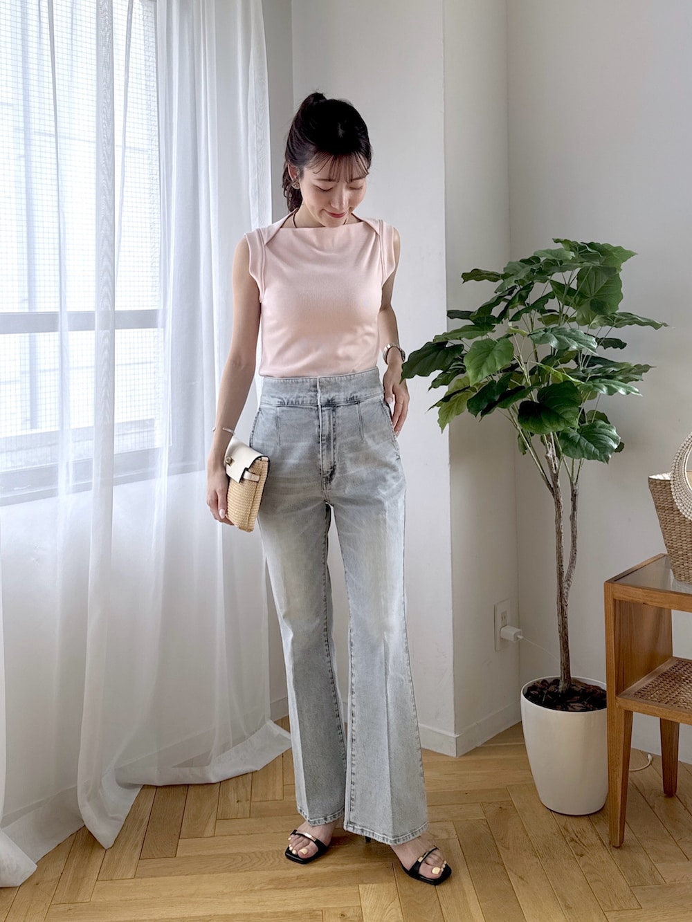 ピンク系のキャミソール、ブルー系のデニムパンツ、ブラック系のサンダルを着用したレディースの春コーディネートの4枚目の写真