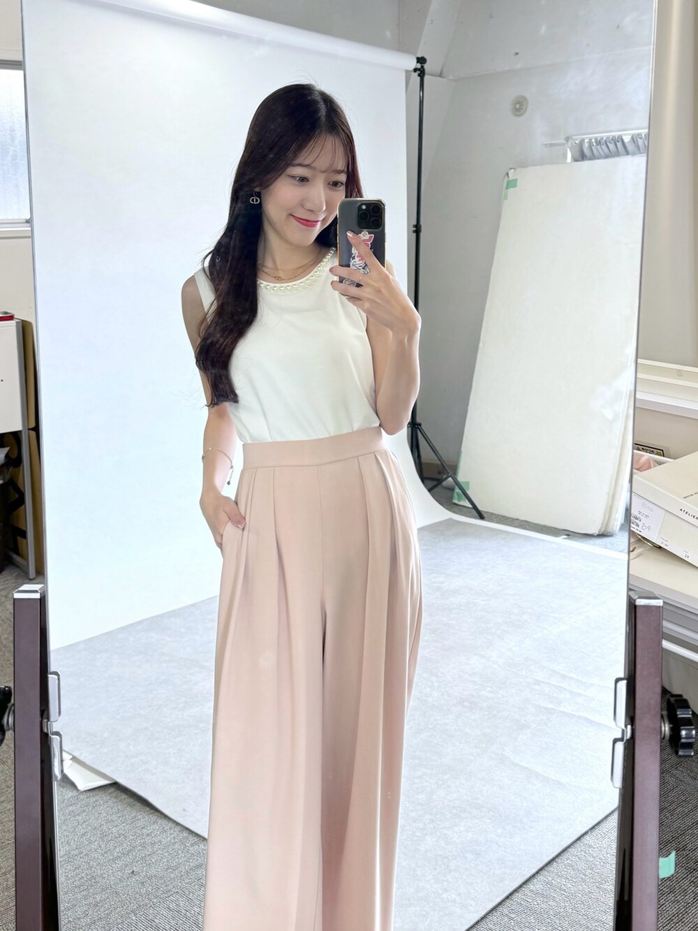 ピンク系のスラックス、ホワイト系のタンクトップを着用したレディースの春コーディネートの4枚目の写真