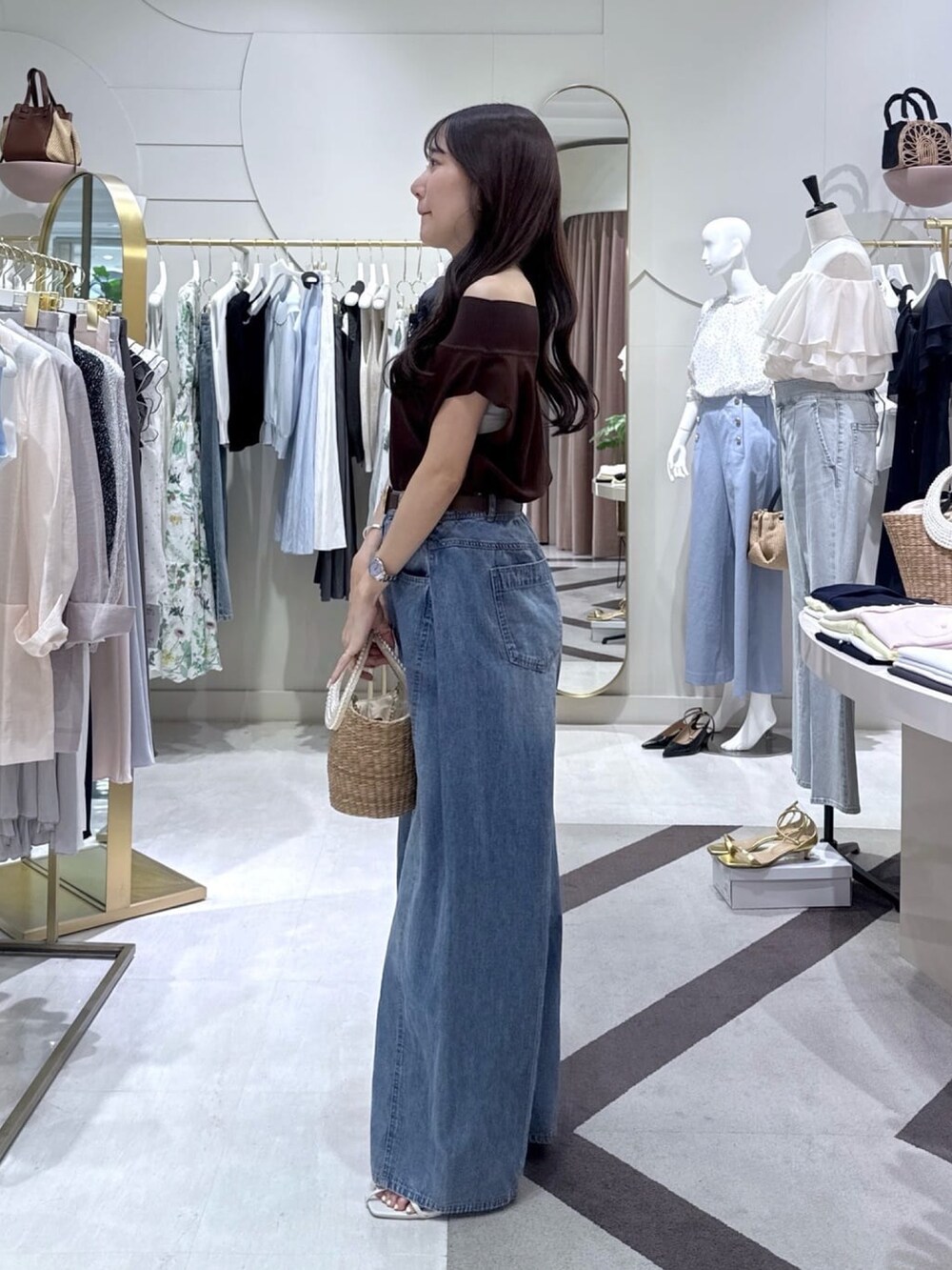 ブラウン系のニット/セーター、ブルー系のその他パンツ、ベージュ系のかごバッグを着用したレディースの夏コーディネートの3枚目の写真