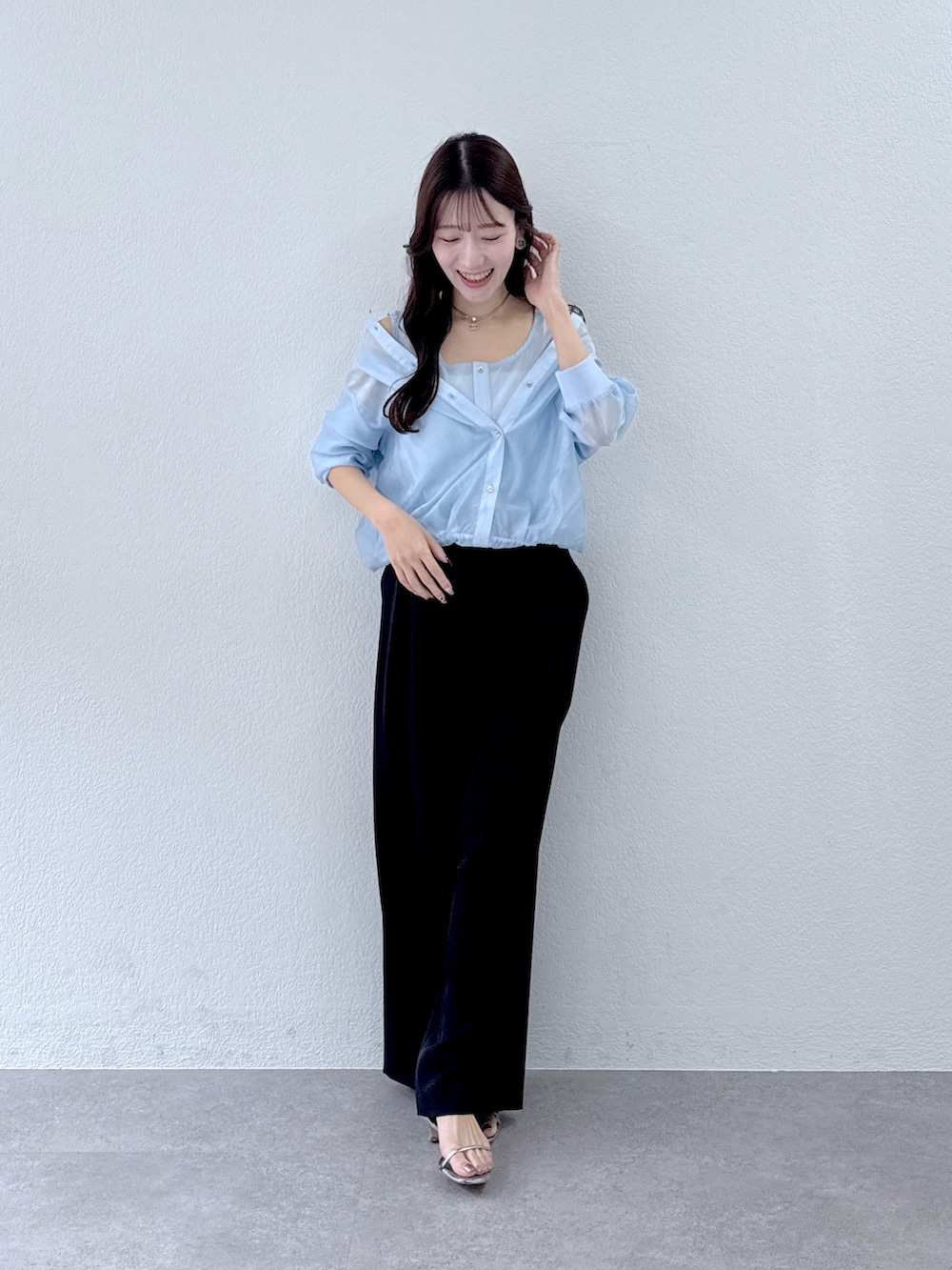 ブルー系のシャツ/ブラウス、ブラック系のスラックスを着用したレディースの冬コーディネートの2枚目の写真