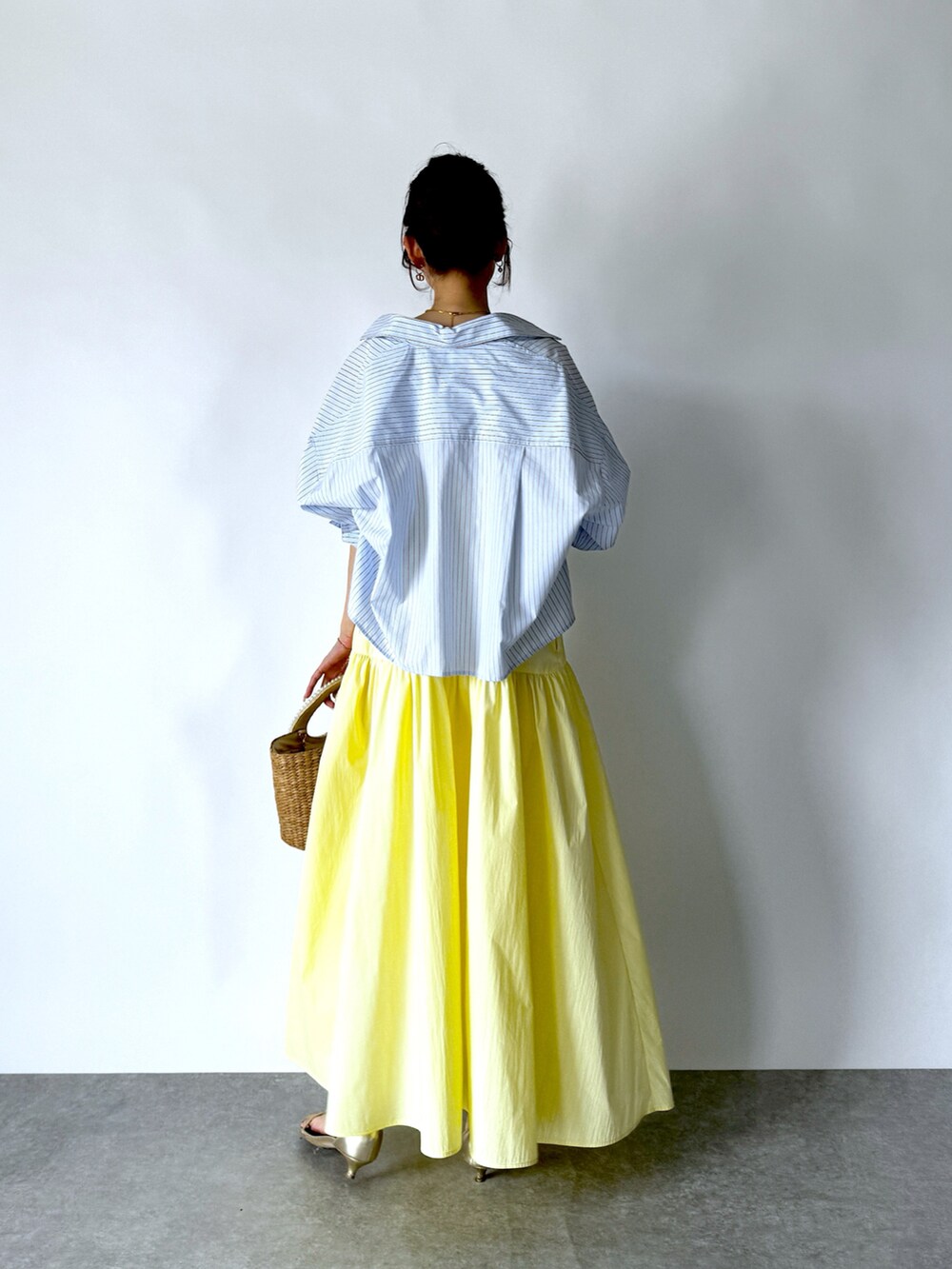 イエロー系のワンピース、ブルー系のシャツ/ブラウス、ホワイト系のタンクトップを着用したレディースの夏コーディネートの4枚目の写真