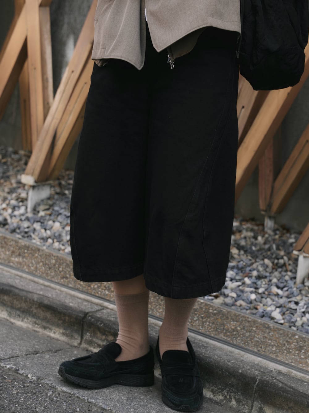 ベージュ系のセットアップ、ブラック系のショルダーバッグ、ブラック系のデニムパンツを着用したメンズの秋コーディネートの4枚目の写真