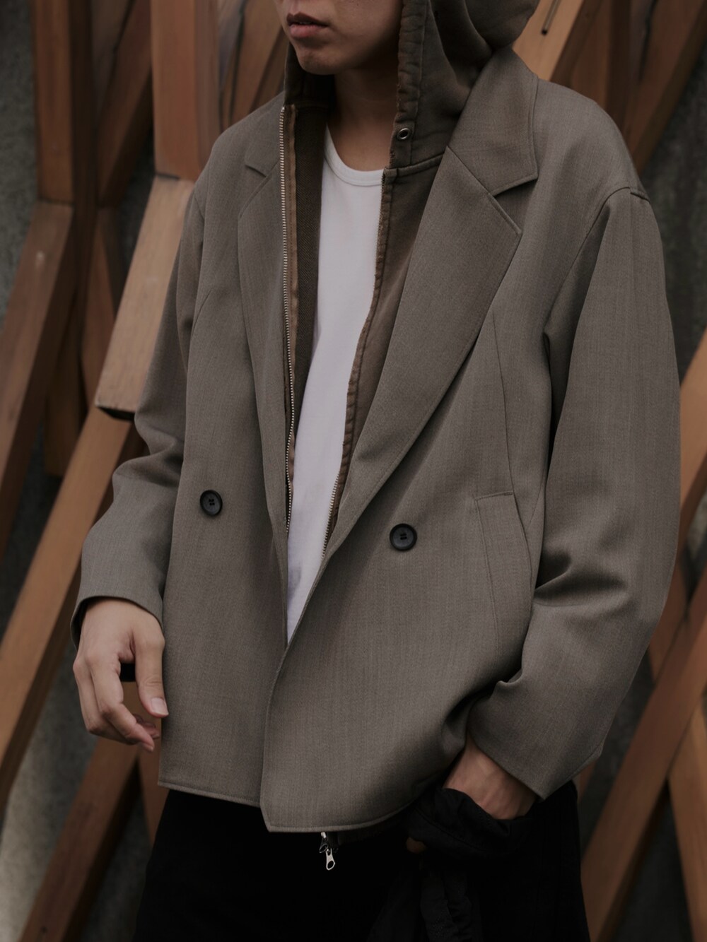 ベージュ系のセットアップ、ブラック系のショルダーバッグ、ブラック系のデニムパンツを着用したメンズの秋コーディネートの2枚目の写真