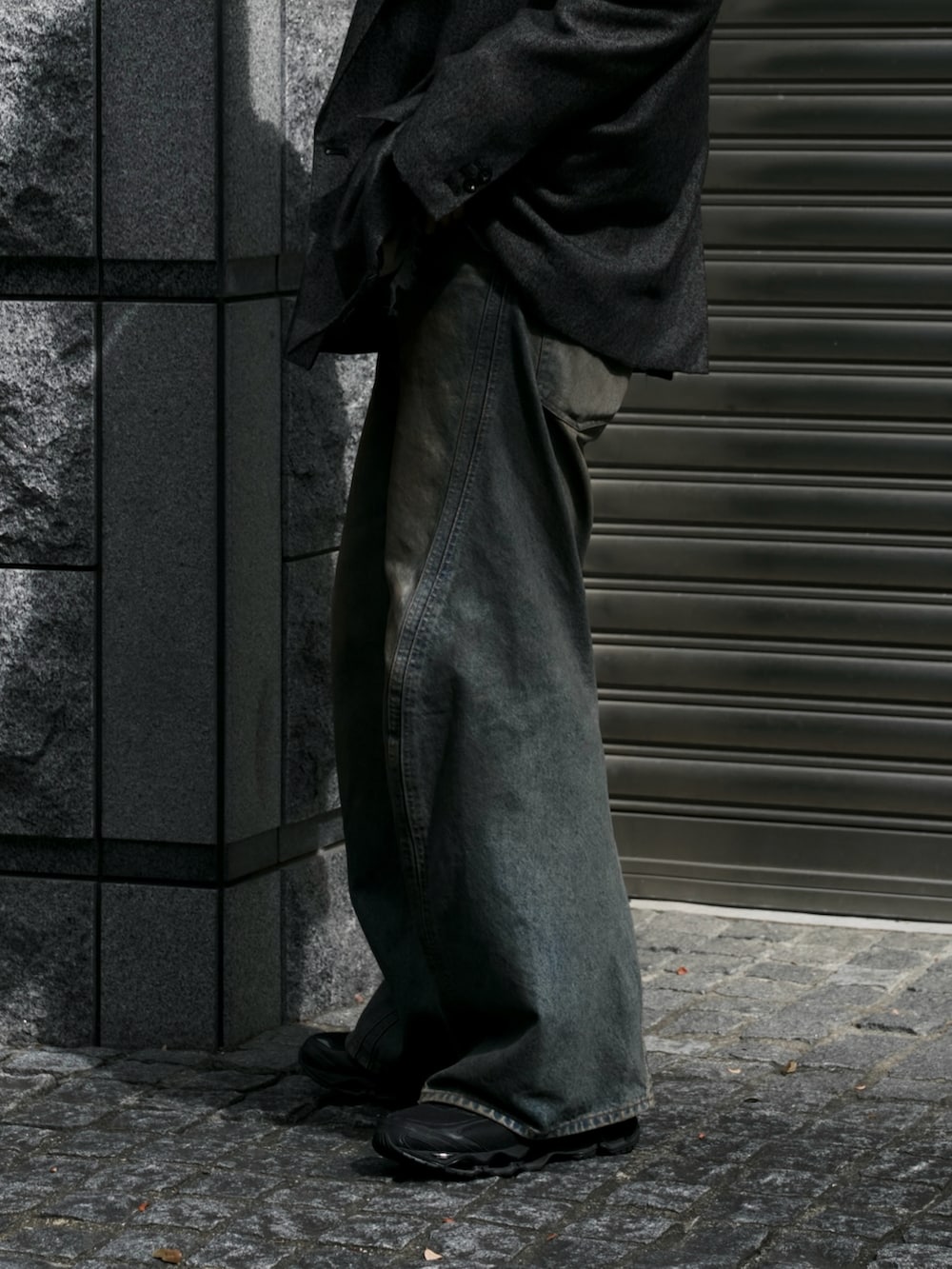 ブラウン系のテーラードジャケット、グレー系のパーカー、ブルー系のデニムパンツを着用したメンズの秋コーディネートの3枚目の写真