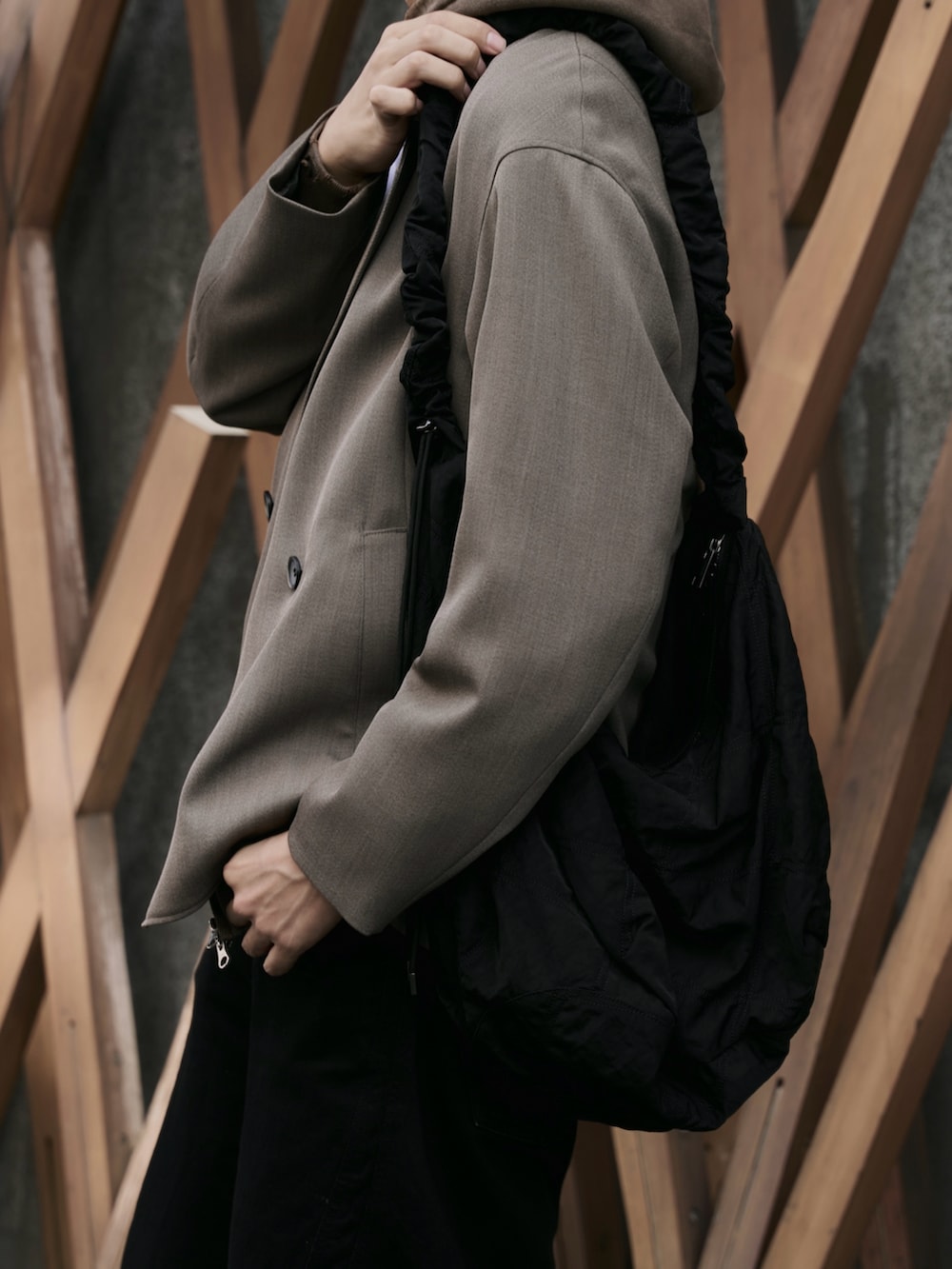 ベージュ系のセットアップ、ブラック系のショルダーバッグ、ブラック系のデニムパンツを着用したメンズの秋コーディネートの3枚目の写真