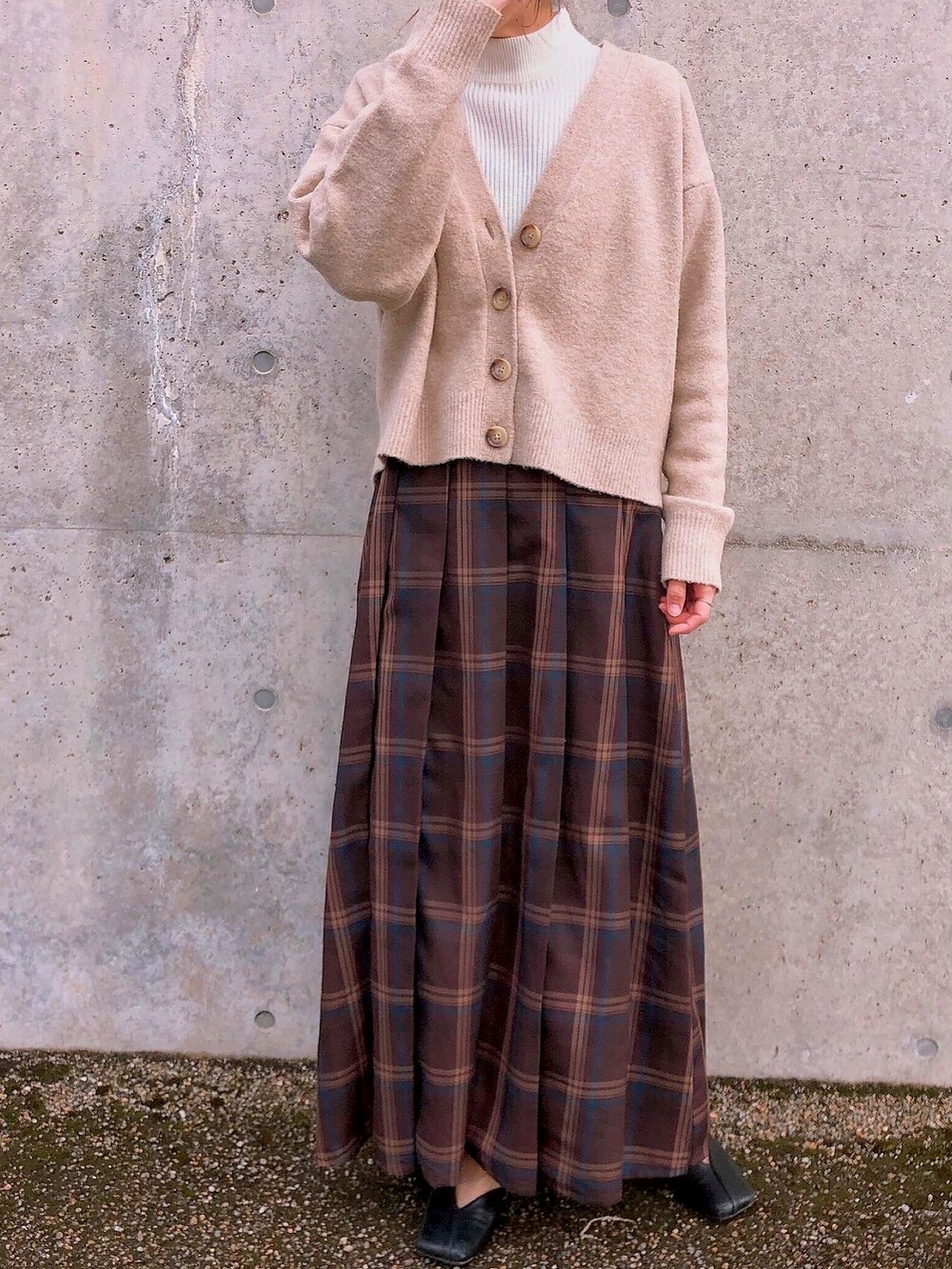ブラウン系のスカート、ホワイト系のニット/セーターを着用したレディースの冬コーディネートの2枚目の写真