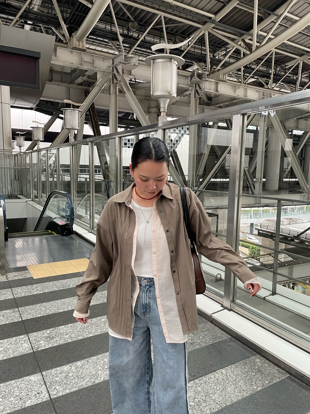 ブラウン系のシャツ/ブラウス、ブルー系のデニムパンツを着用したレディースの春コーディネートの5枚目の写真