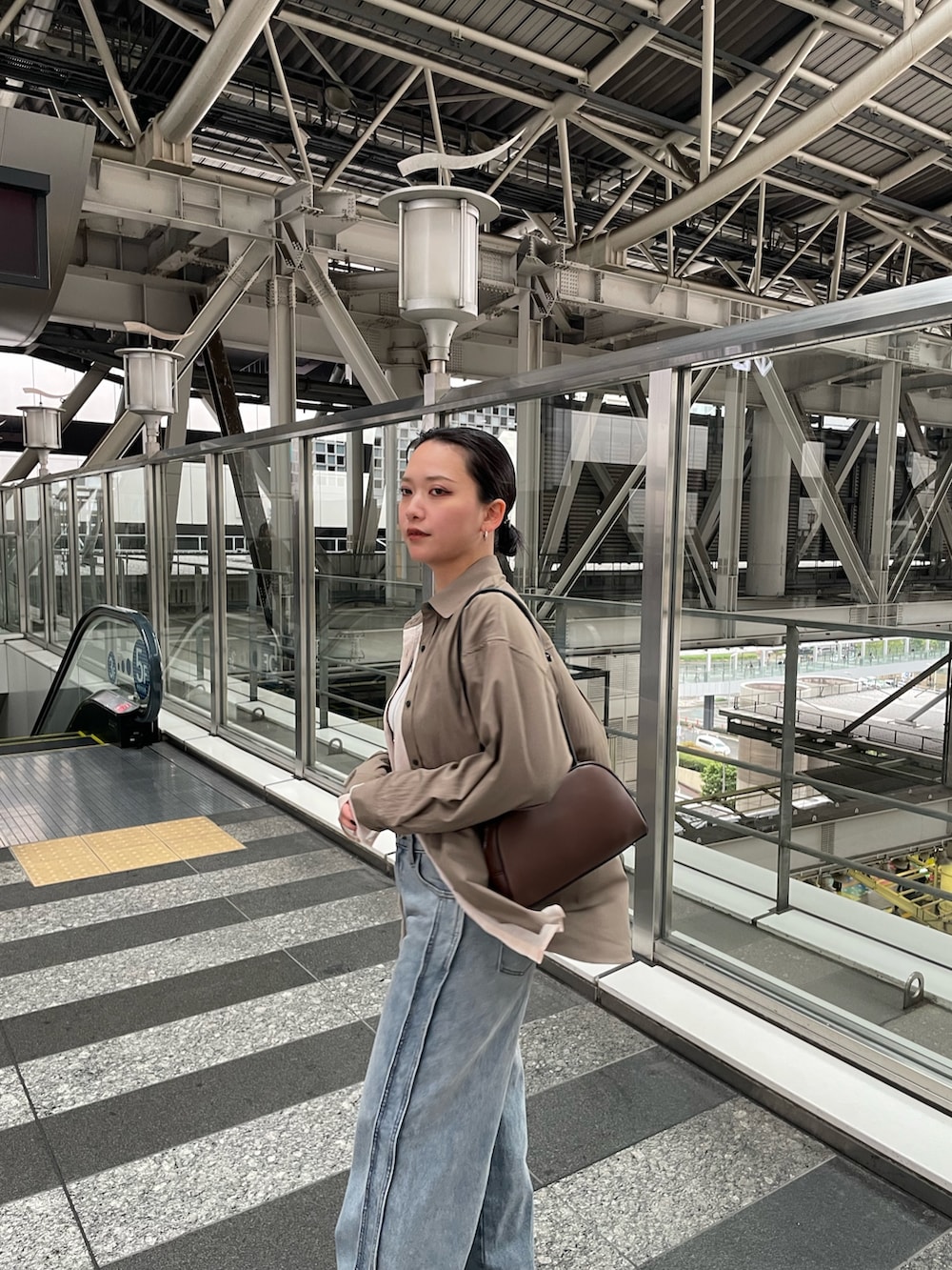 ブラウン系のシャツ/ブラウス、ブルー系のデニムパンツを着用したレディースの春コーディネートの6枚目の写真