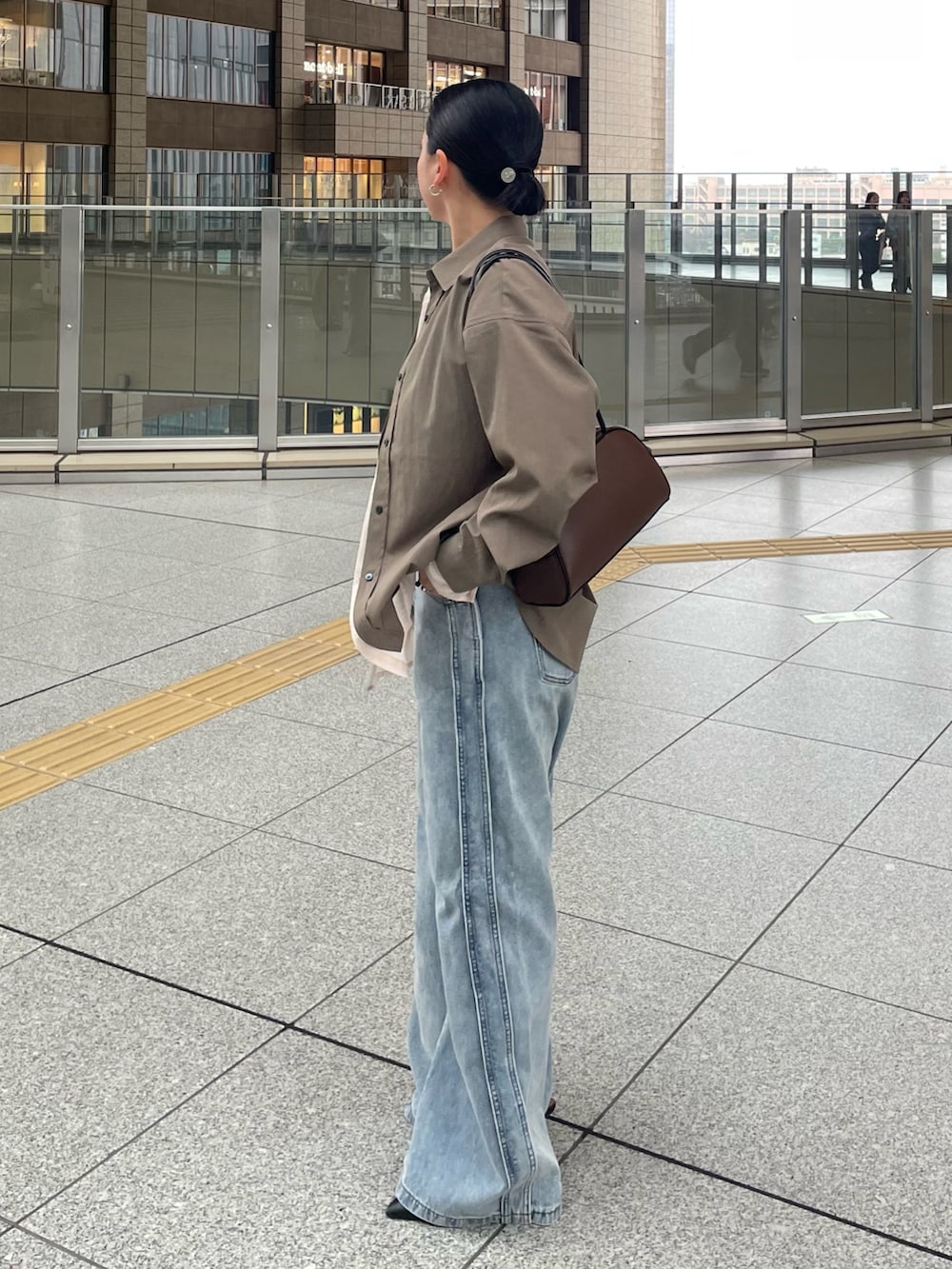 ブラウン系のシャツ/ブラウス、ブルー系のデニムパンツを着用したレディースの春コーディネートの2枚目の写真