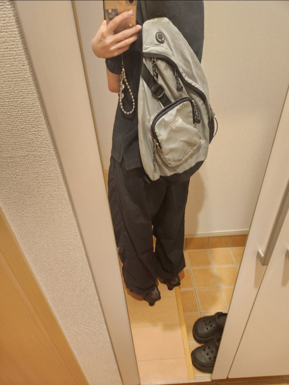 ブラック系のスニーカー、ブラック系のその他パンツ、ブラック系のTシャツ/カットソーを着用したレディースの秋コーディネートの2枚目の写真