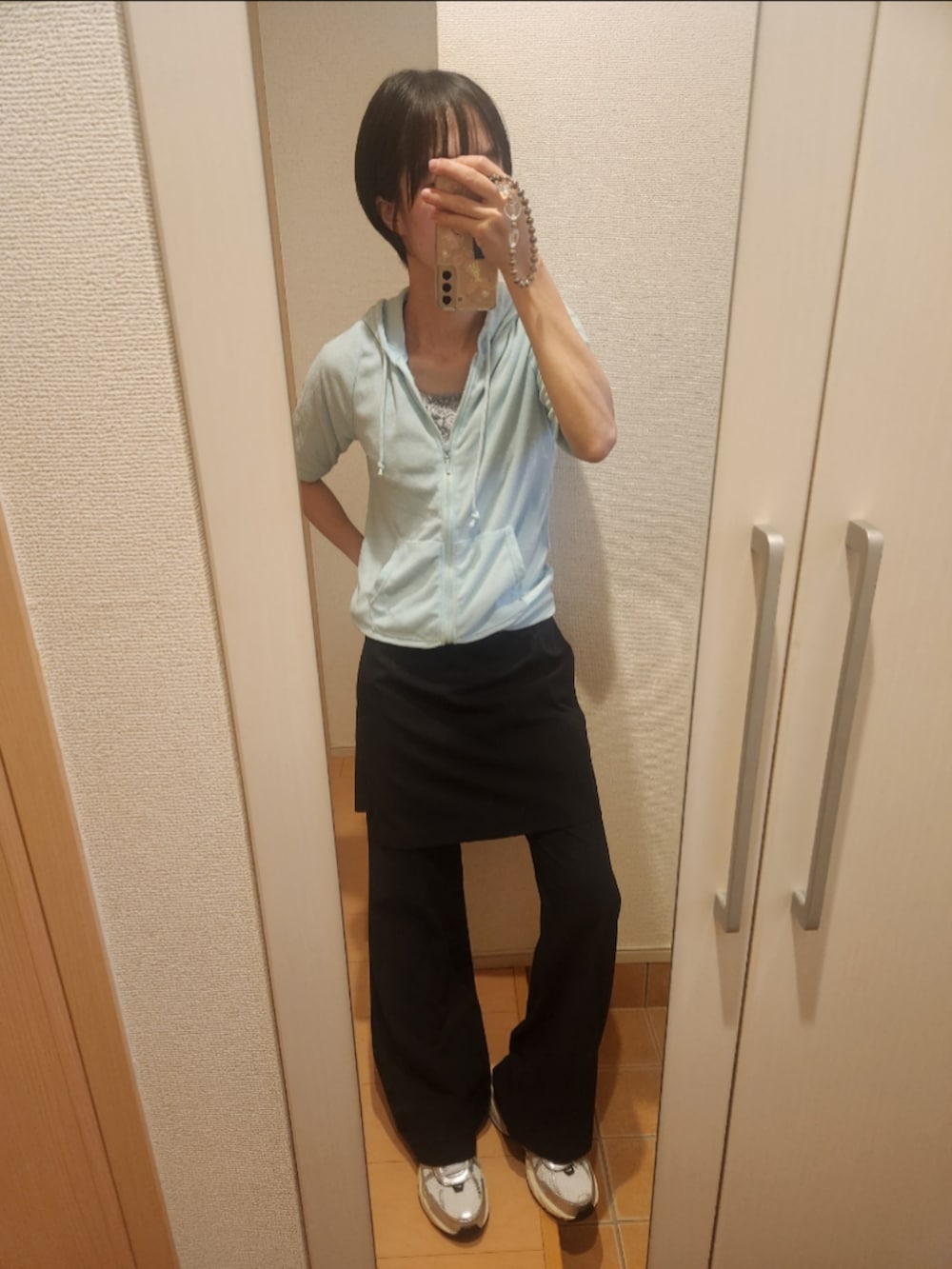 ブルー系のパーカー、ブラック系のその他パンツ、ホワイト系のスニーカーを着用したレディースの秋コーディネートの2枚目の写真