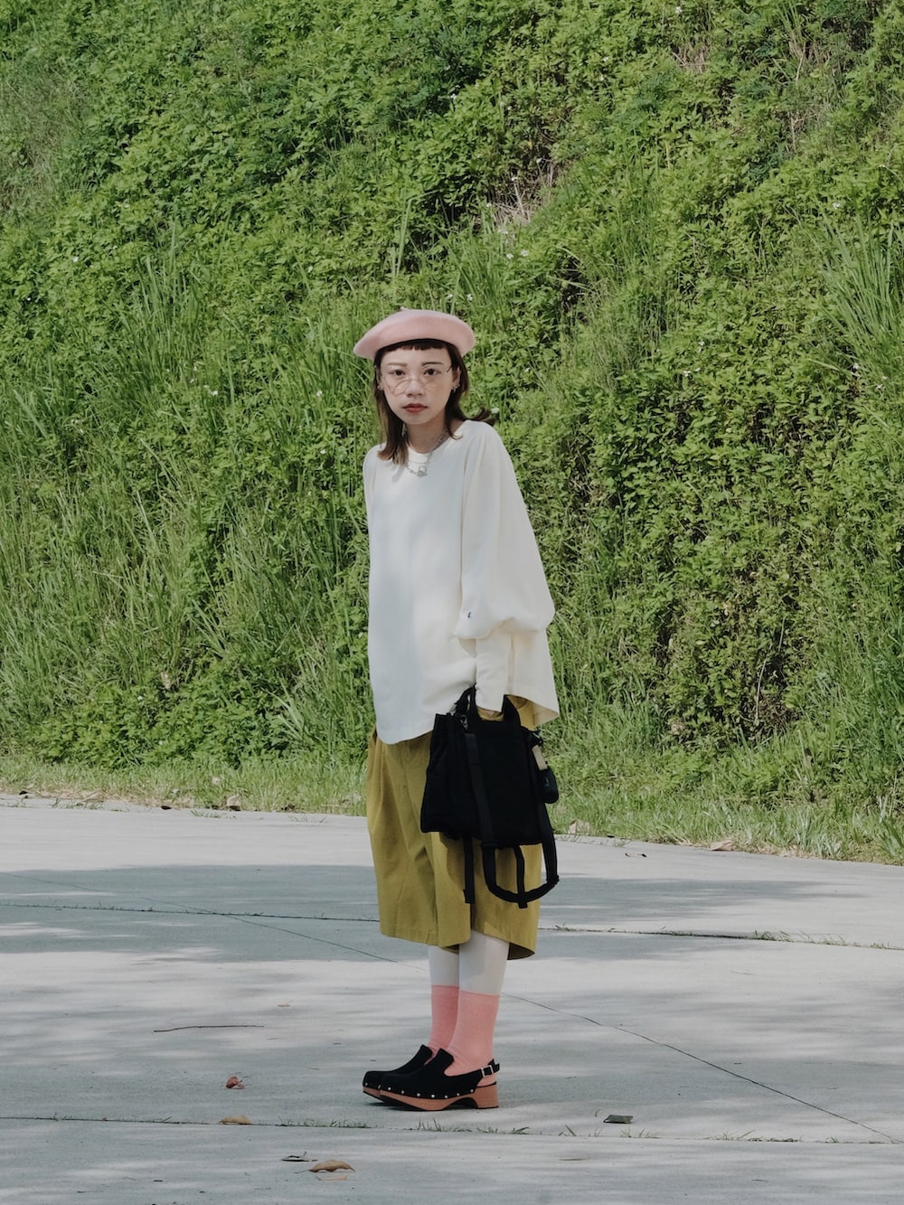 イエロー系のカーゴパンツ、ブラック系のバッグ、ベージュ系のトップスを着用したレディースの春コーディネートの2枚目の写真