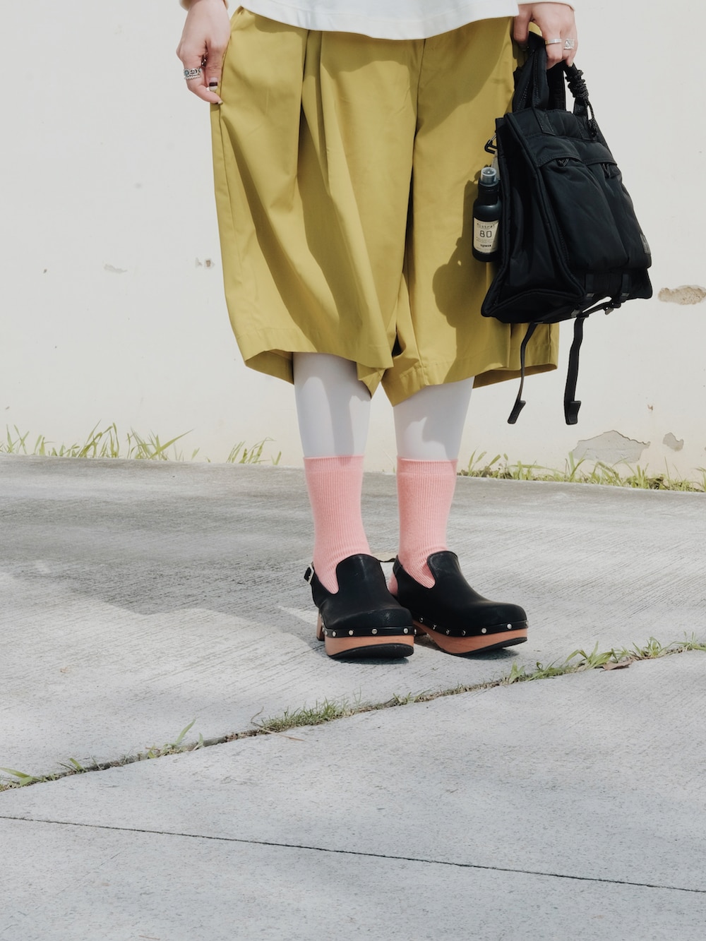 イエロー系のカーゴパンツ、ブラック系のバッグ、ベージュ系のトップスを着用したレディースの春コーディネートの3枚目の写真