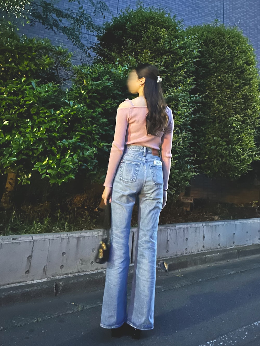 ブラック系のパンプス、ブルー系のデニムパンツ、ブラック系のショルダーバッグを着用したレディースの春コーディネートの2枚目の写真