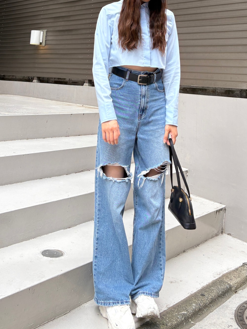 ブルー系のシャツ/ブラウス、ブルー系のデニムパンツ、ホワイト系のスニーカーを着用したレディースの春コーディネートの2枚目の写真