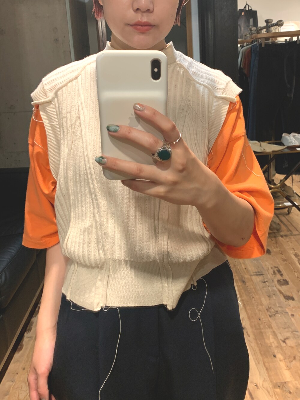 ブルー系のスラックス、オレンジ系のスニーカー、ベージュ系のベストを着用したレディースの冬コーディネートの2枚目の写真