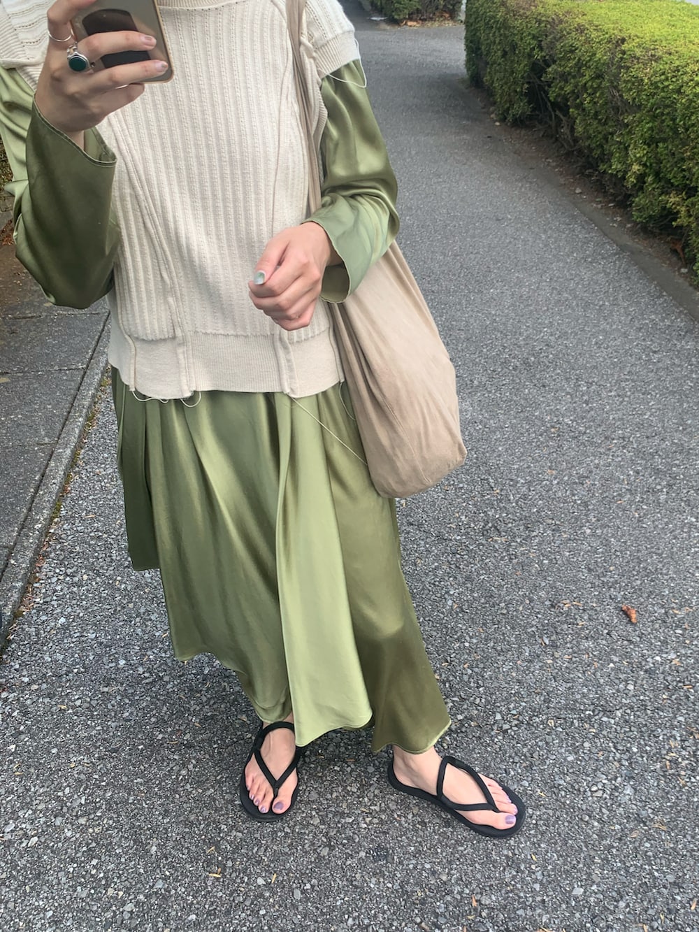 グリーン系のワンピース、ブラック系のブーツを着用したレディースの冬コーディネートの2枚目の写真