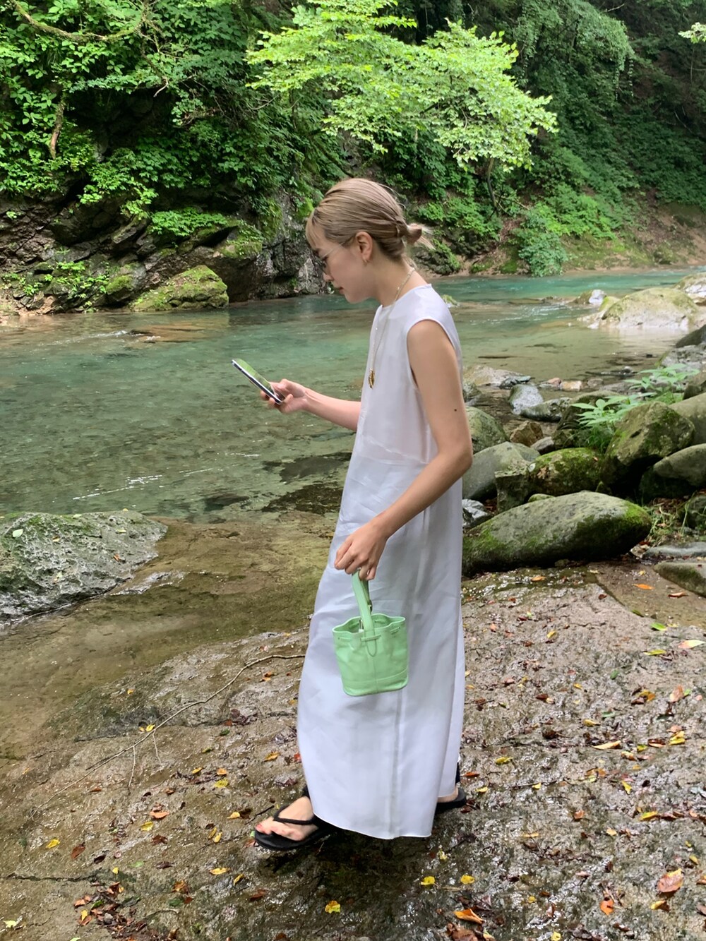 グリーン系のハンドバッグ、ホワイト系のワンピース/ドレス、グレー系のファッション雑貨を着用したレディースの冬コーディネートの2枚目の写真